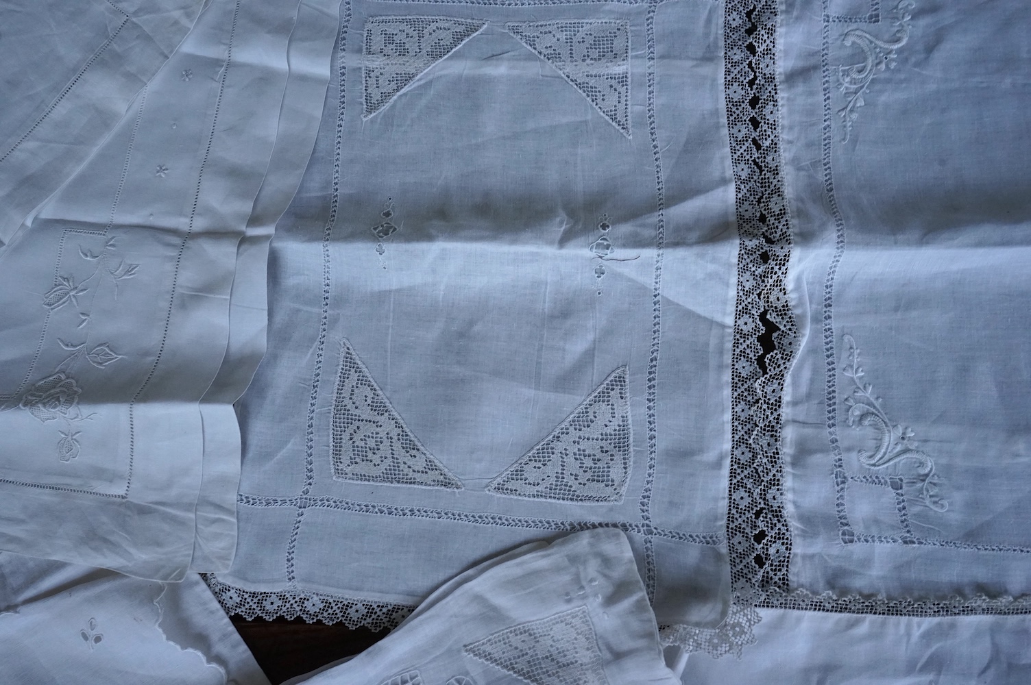 Ten fine linen baby’s pillowcases, eight inset and edged with fillet lace, together with a large fine linen red bordered 19th century ladies kerchief, and three other items. (14) Kerchief 54cm x 58cm. Condition - all ite